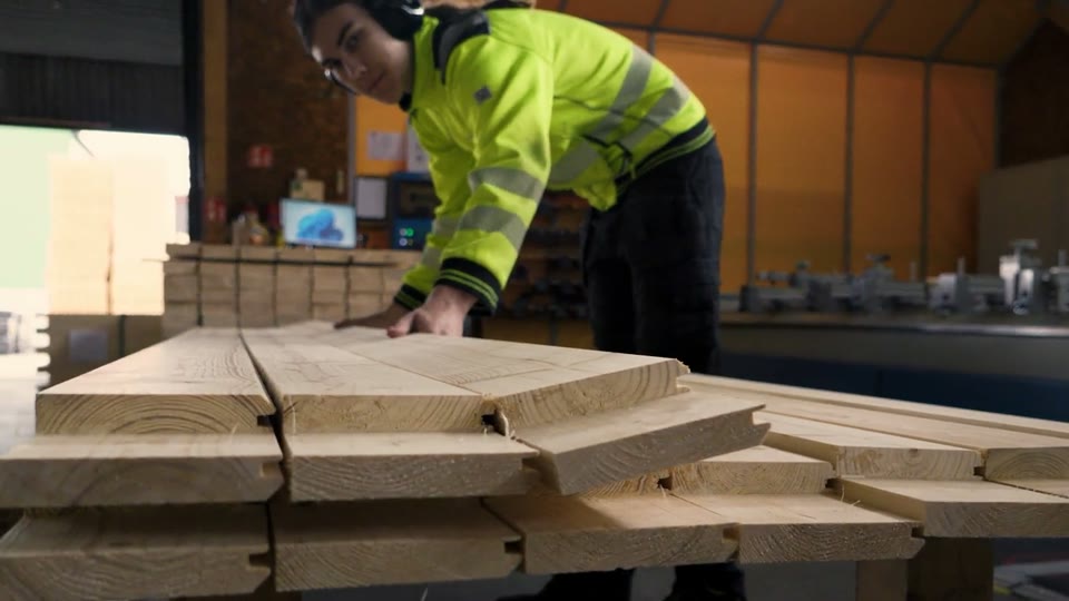 Factory worker checking cut frame boards