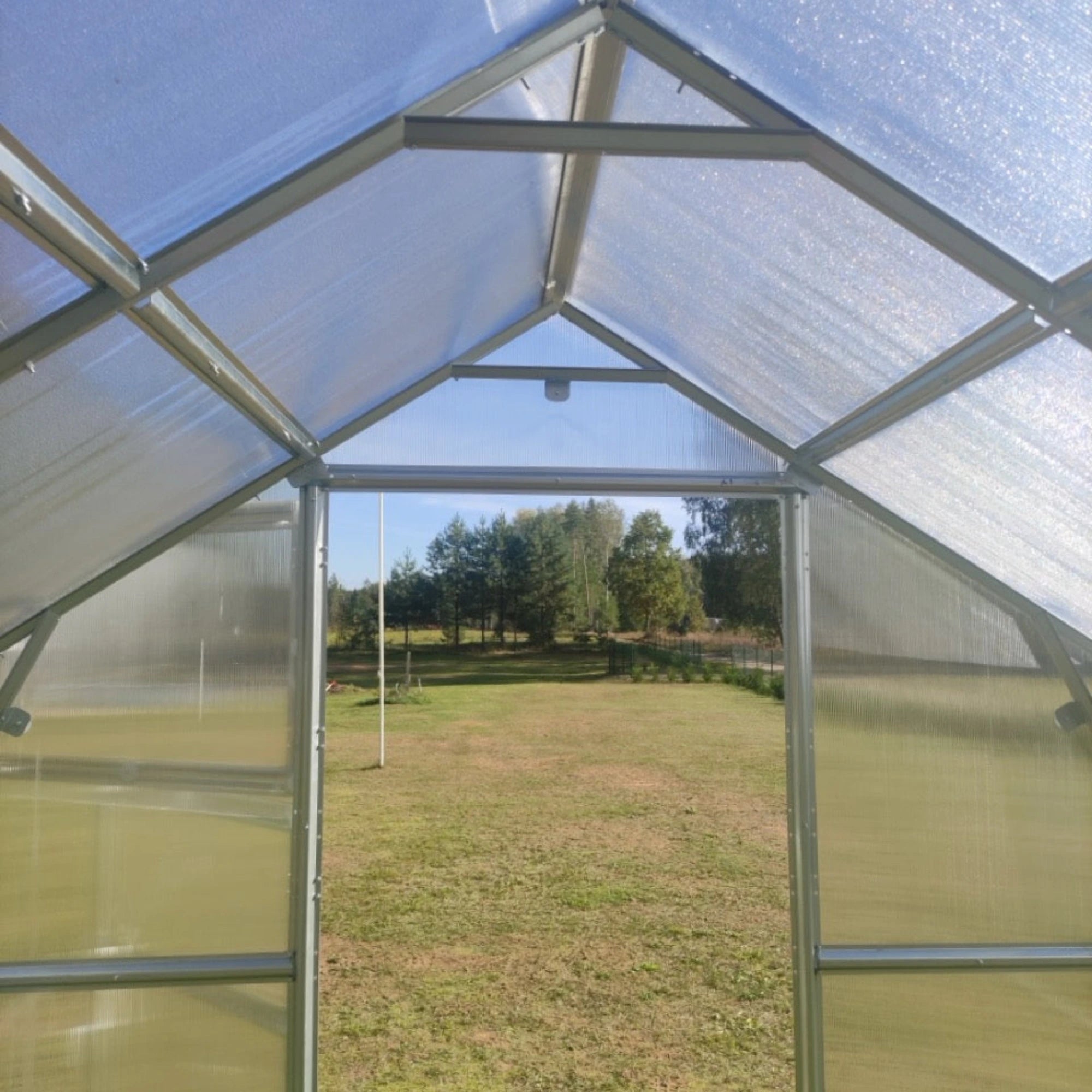 house greenhouse interior with opened doors and backyards visible