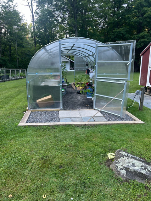A polycarbonate greenhouse in an owner's garden