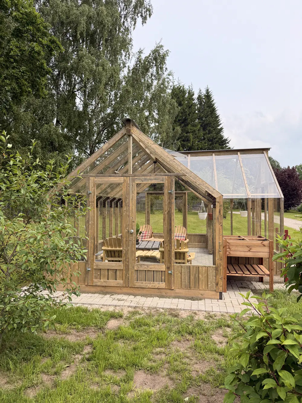 Greenhouse with both doors open onto a garden